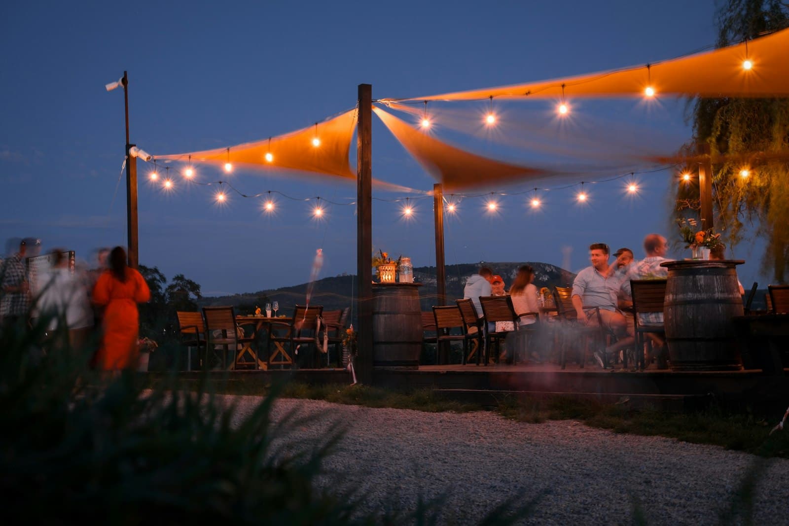 Outdoor dining area under string lights at dusk